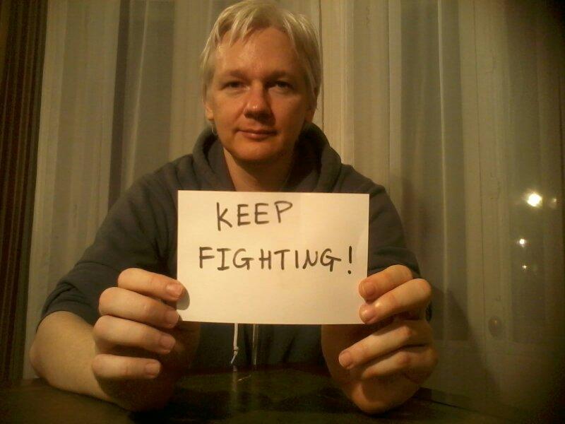 "Continúen luchando", dice un papel que sostiene Julian Assange. Foto: Wikileaks