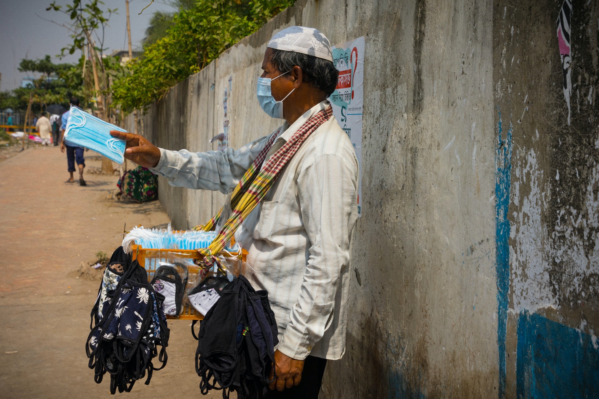 Un hombre vende mascarillas en una calle de la localidad de Dhaka, en el centro de Bangladesh. Foto: UNsplash / Mostafijur Rahman 