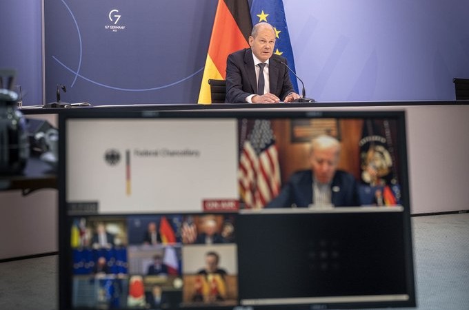 Al fondo el canciller alemán, Olaf Scholz, habla mientras en la pantalla se ven a los demás líderes del G7. Foto: Twitter / G7