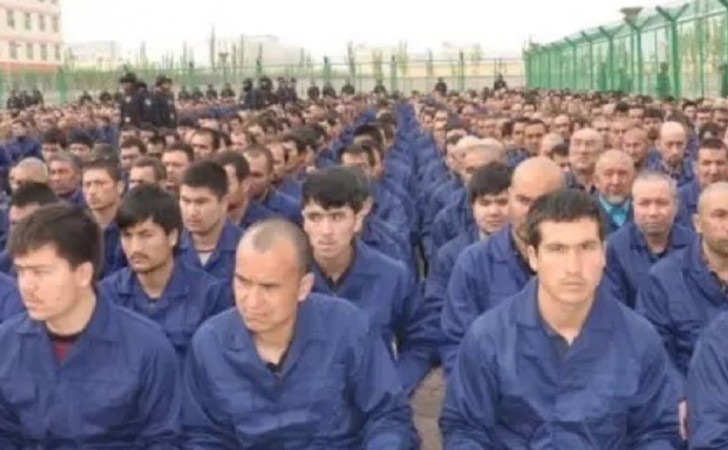 Fotografía revelada en la filtración de los Archivos Policiales de Xinjiang, en donde se ven a decenas de uigures sentados en el piso en lo que pareciera ser una cárcel. 