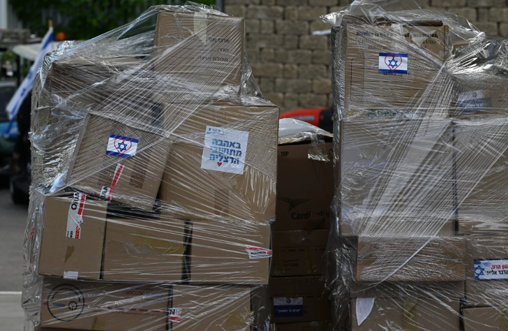 Cajas de suministros donados. El cartel dice: "Con cariño de parte de los residentes de Herzliya". Tanya Habjouqa/NOOR para NPR