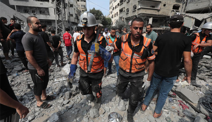 Imagen verificada por la agencia de noticias palestina Wafa de rescatistas buscando sobrevivientes entre los escombros de los bombardeos israelíes