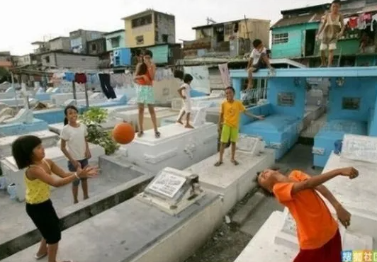 Niños juegan sobre tumbas en el cementerio de Manila, Filipinas.