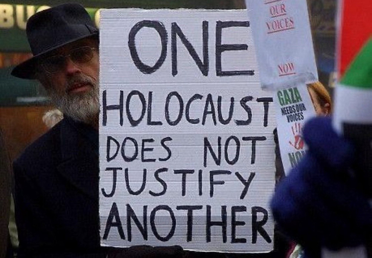 "Un holocausto no justifica otro", dice el cartel de un manifestante en una marcha contra el genocidio perpetrado por Israel en Palestina. 